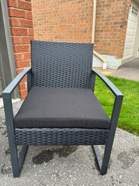Set of four wicker style patio chairs and cushions. 