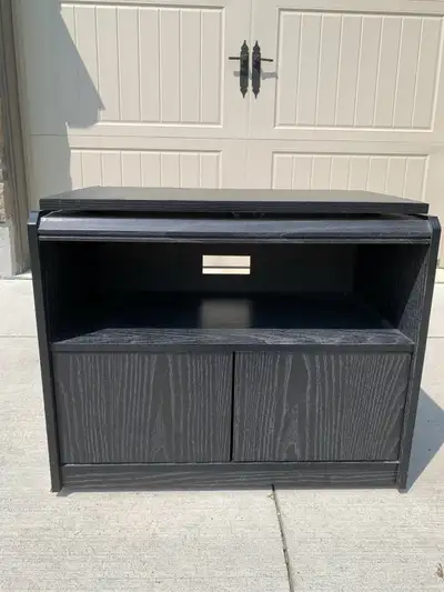 Wooden TV stand. Black. Top swivels. Wheels. Double door cabinet. Can pick it anytime.