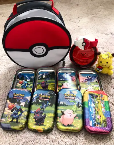 4 mini tins with cards (as shown). 1 lunch bag with accessories Pikachu key chain no longer availabl...