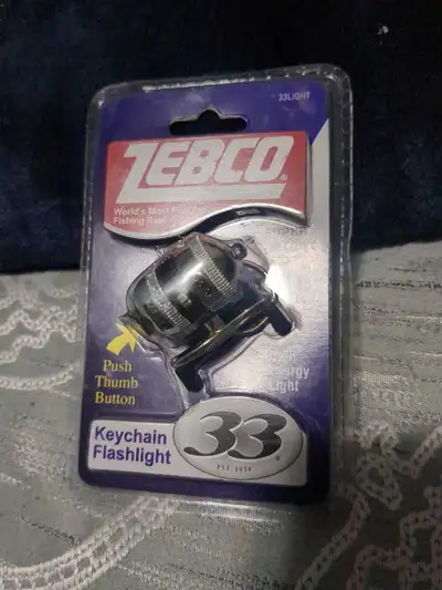 Light up your path with this brand new, sealed Zebco 33 keychain flashlight, designed with the iconi...