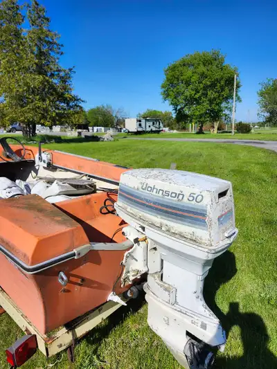This is a vintage boat with a Johnson 50 motor and trailer, perfect for a restoration project or for...