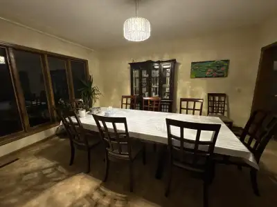 Wooden dining table with 10 chairs and a hutch , View more