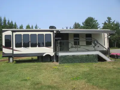 Like new Sandpiper luxury destination trailer, lots of windows giving a panoramic view from the livi...