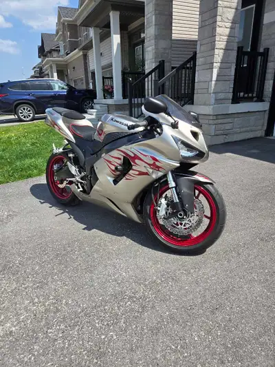 This is a 2006 Kawasaki ZX-6R motorcycle. It's a silver sportbike with red flame decals. It has 17,7...