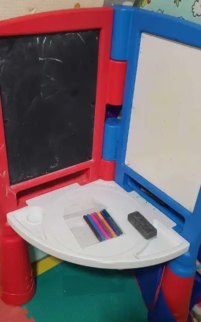 I'm selling a used kids' easel featuring a chalkboard on one side and a whiteboard on the other, pro...