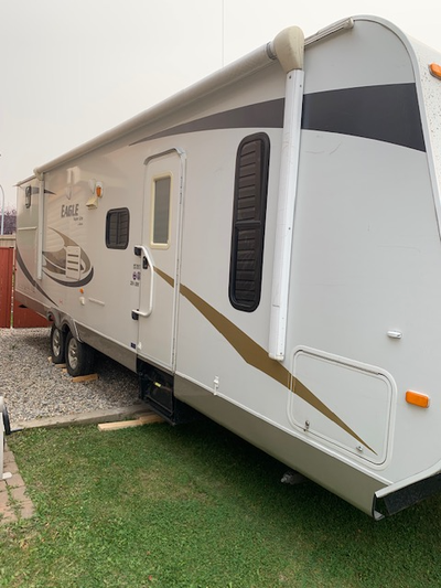 32-foot travel trailer featuring rear bunkhouses, an exterior kitchen and an outside shower, making...