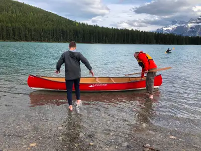 2020 gently used iconic Canadian Langford canoe in red and white. Includes wooden paddles and mounti...