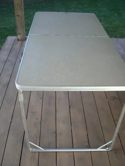 Coleman, lightweight portable table, with handle. Measures 5 feet x 30 inches. When folded measures...