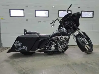 This stunning custom-built chopper by Stinger Cycles features a sleek black finish with intricate sk...