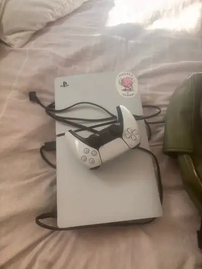 This is a white PlayStation 5 console with a matching controller. It's ready for all your gaming nee...
