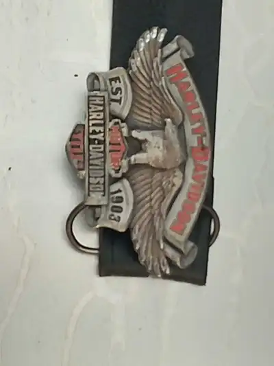 This is a vintage Harley-Davidson belt buckle featuring the classic winged logo and the Est. 1903 em...