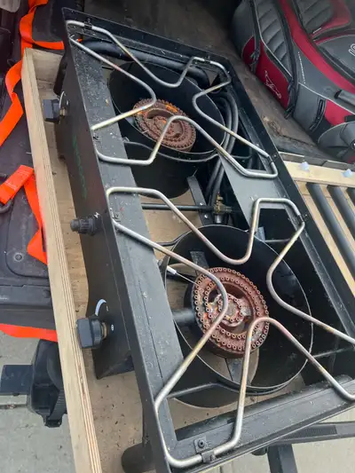 This is a Woods camping stove featuring two burners, perfect for outdoor cooking. Includes a wood st...