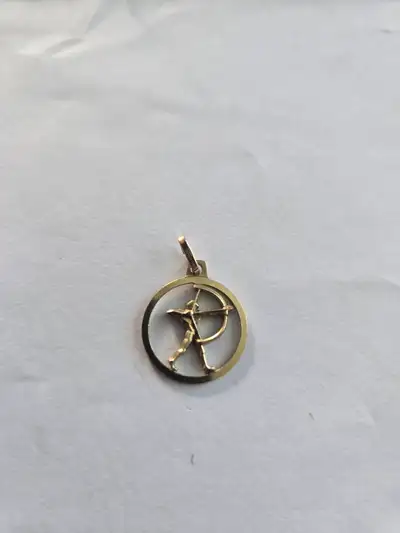 Elegant 8k gold pendant with a circular frame enclosing a Sagittarius archer figure. This piece is m...