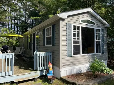 Trailer includes deck, patio table with four chairs, full size fridge, cutlery, dishes, pots and pan...