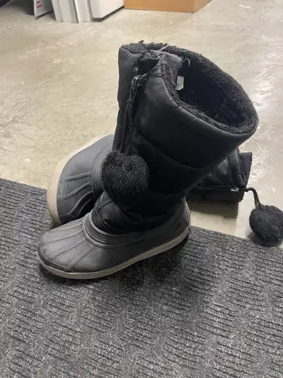 Black Pajar size 2 youth winter boots with a zipper closure and a fuzzy pom pom on the top. Waterpro...