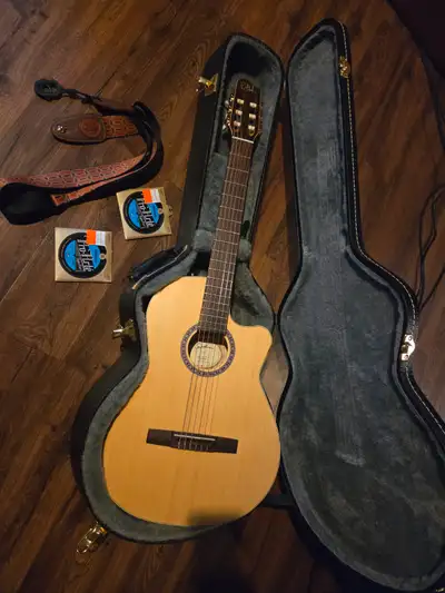 Beautiful nylon acoustic electric. Comes with hard case, strap, and 2 extra sets of strings. Like ne...