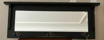 Wooden mirror with 6 hooks, beveled glass, 2 1/2” ledge on top. 33” x 13” Hooks on back for hanging.