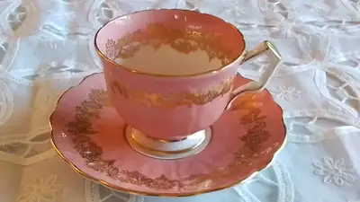 FINE BONE CHINA CUP AND SAUCER - AYNSLEY. MADE IN ENGLAND. PINK AND WHITE WITH GOLD DESIGN. EMBOSSED...