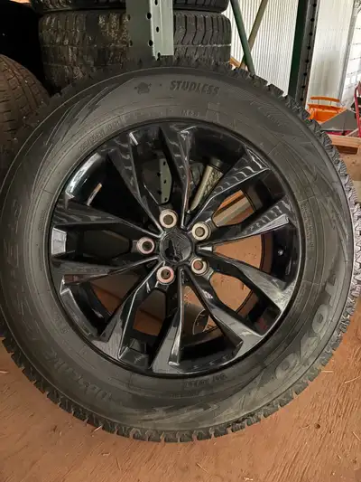 Studless Toyo Observe winter tires are size 235/65R17 104H. The set includes black multi-spoke rims....