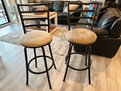 Two Bar Stools for sale. One with a light cushion and one with a dark cushion otherwise the exact sa...