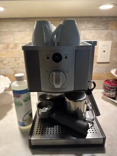 Breville Cafe Roma cappuccino machine with descaling solution, four cups and frothing cup.