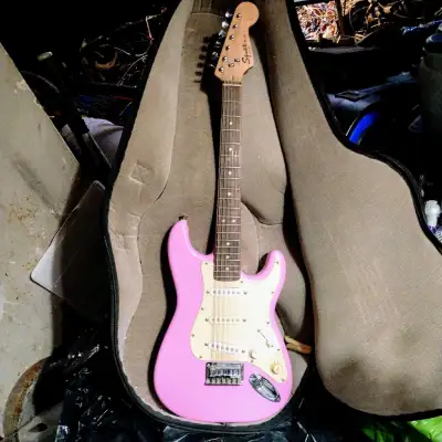 This is a Squier Mini Strat electric guitar, perfect for beginners or those with smaller hands, feat...