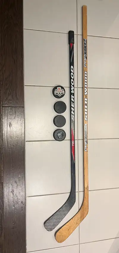 2 junior hockey sticks and 4 pucks right handed sticks, View more