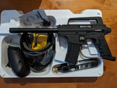 Brand new in box, never used Tippmann Bravo One paintball marker. Includes helmet/goggle, CO2 tank (...