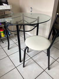 Glass top kitchen table with four chairs (also black seats)