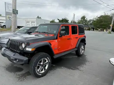 Black and Orange Jeep Wrangler with tow hitch. Soft Top comes with it.