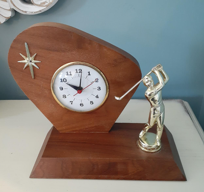 This fun MCM clock is solid wood on a solid wood base. It features a gold atomic starburst and a gol...