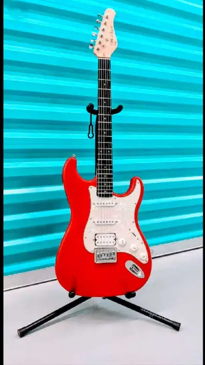 This is a vibrant red Optek Fretlight 400 Series Strat-style electric guitar, perfect for learning o...