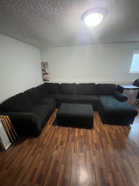 Large sectional couch with pull out double bed and ottoman.