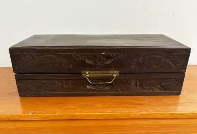 Antique carved chess set. Brass fittings. Folds in half. Two incorporated drawers hold the carved pi...