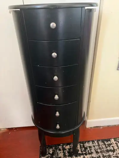 This elegant black jewelry armoire features six spacious drawers, and a mirror top. providing ample...