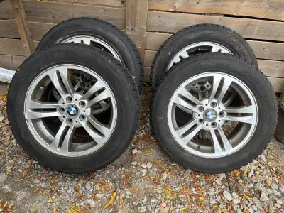 These are a set of four used BMW winter tires mounted on rims, sized at 235/55R17. They are Antares...