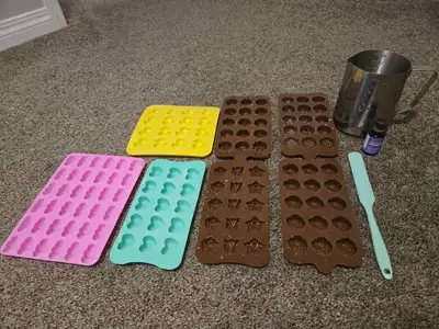 Supplies for making candles or soaps. Includes 7 silicone molds, pitcher, silicone spatula, and lave...