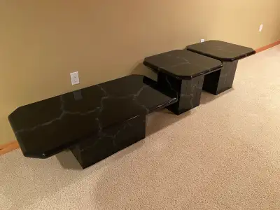 Elevate your living space with this striking black faux marble coffee table, complemented by two mat...