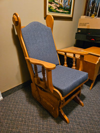 Chaise berçante en bois avec coussins gris.