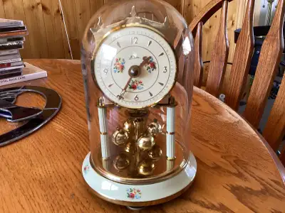 “Vintage German Kern anniversary style quartz clock with rotating pendulum and glass dome”. Made by...