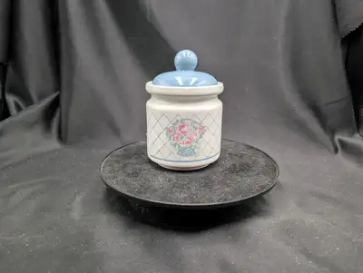 A 1989 Vintage Market Square Ceramic Storage Jar with blue lid. The body of the jar features a white...