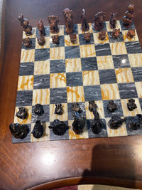 Vintage carved stone chess set. 14”x14”.