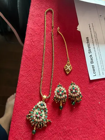 This is a used Indian jewelry set including a necklace, earrings, and a tikka, perfect for adding a...