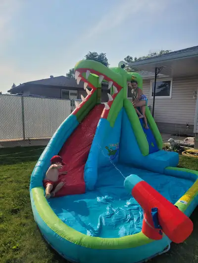 Large alligator water slide with attached pool and water gun. PERFECT condition, no rips, tears or w...