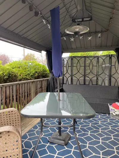 Outdoor table with tempered glass top. Seats up to 6 comes with umbrella and stand