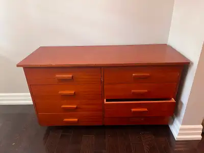 Wood dresser has a reddish-brown finish and eight drawers. This piece features a double-column layou...