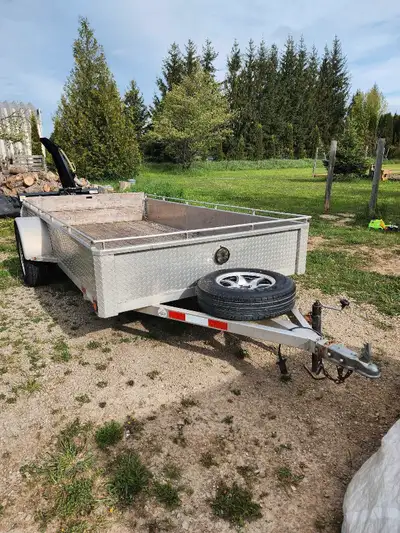12' Bearco aluminum trailer. In good shape. Everything is working. Has a spare tire and the rear gat...