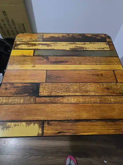 This is a folding table with a wood plank design. It's easy to set up and store. The metal legs prov...