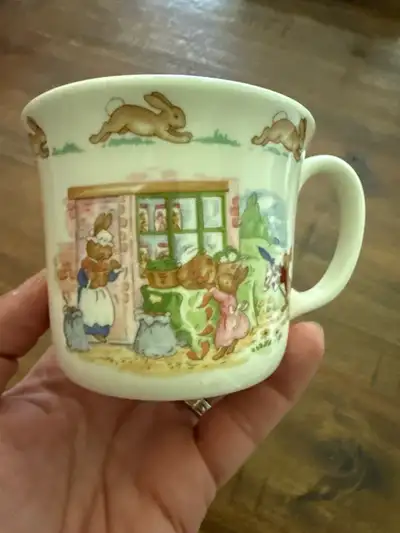 This is a charming, vintage Royal Doulton Bunnykins bone china mug featuring delightful scenes of th...