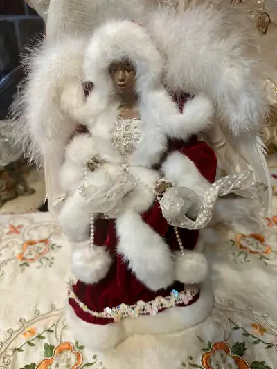 The tree topper is 14 inches tall. It has faux fur on the hood and the coat.